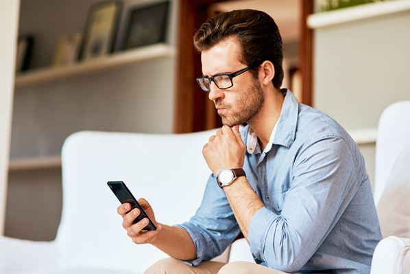 Pensive customer looking at his phone